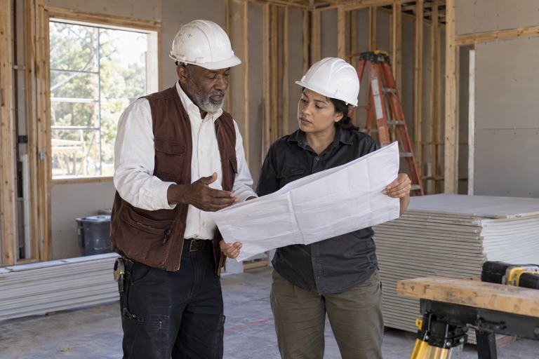 Contractors reviewing plans on a job site