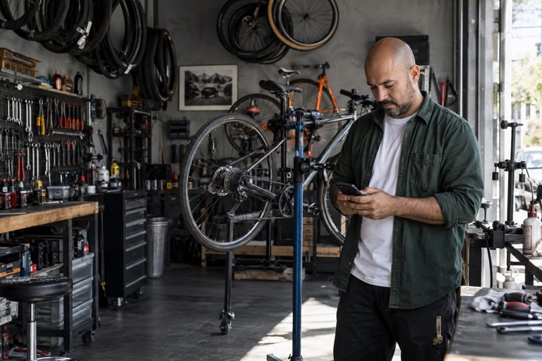Bike shop owner checking his phone